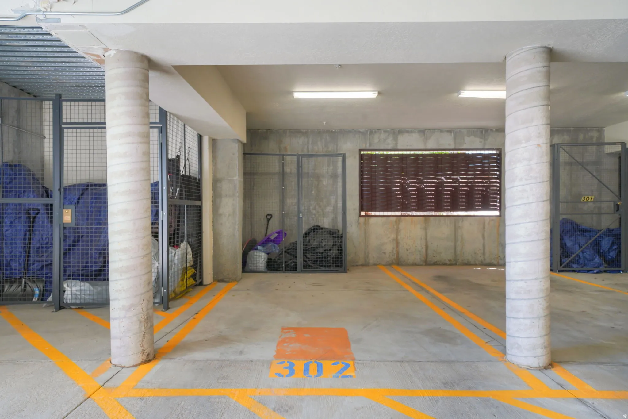 Designated parking space with clear demarcation lines, illuminated by overhead fluorescent lighting