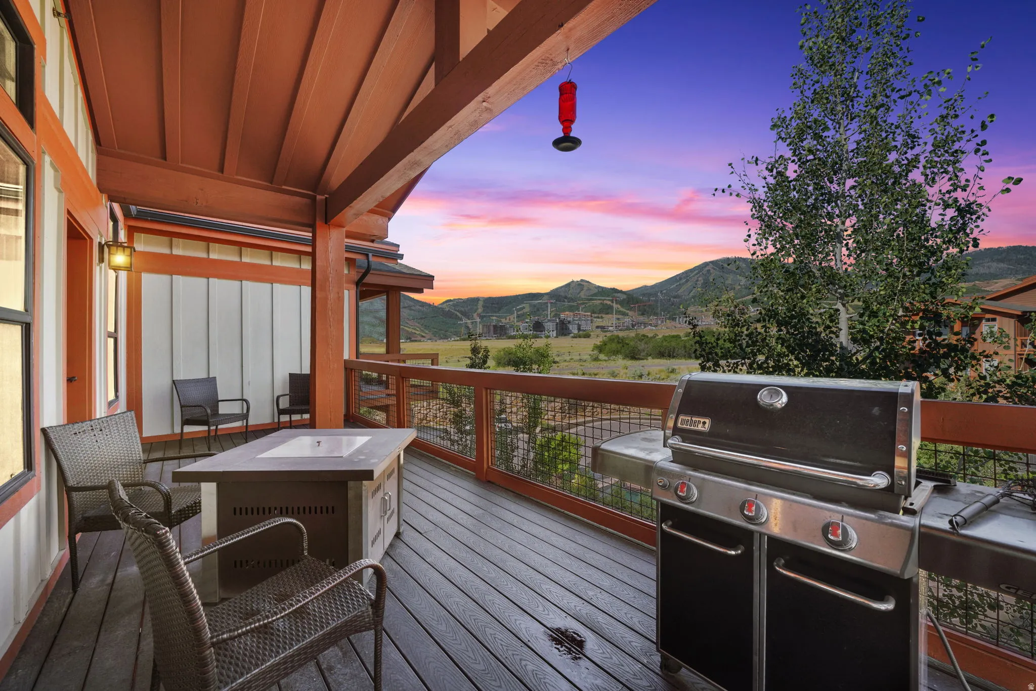 Covered outdoor deck featuring wood-finish flooring and exposed wooden beams