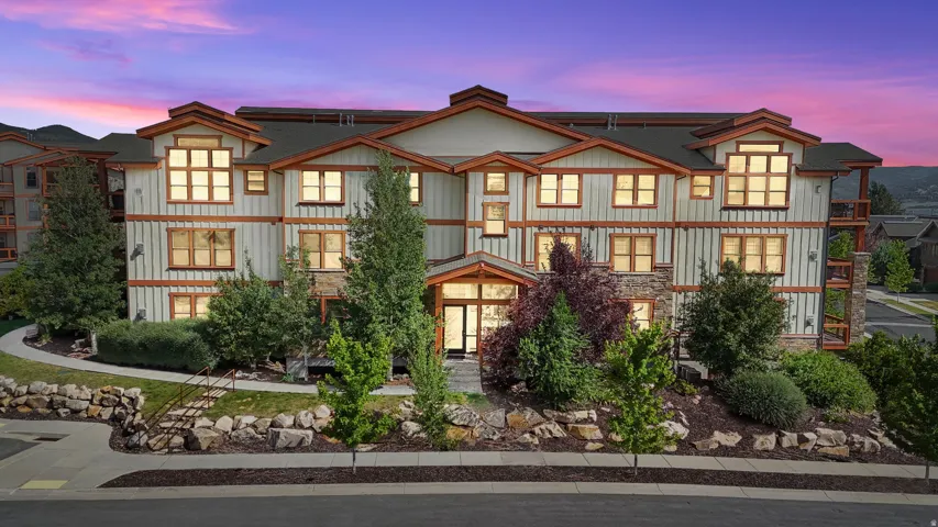 Multi-story residential building featuring board-and-batten siding with stone accents