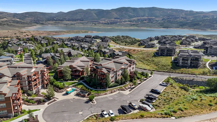 Elevated aerial perspective showcasing a residential community with a large body of water and mountains in the background