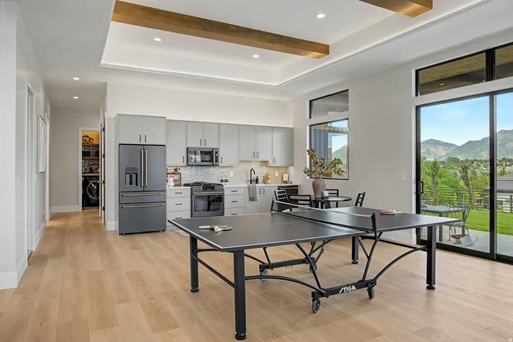 Modern kitchen featuring light gray cabinetry, stainless steel appliances, and a tiled backsplash