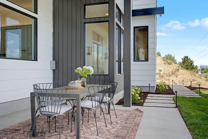 Exterior patio featuring white horizontal siding and dark vertical paneling
