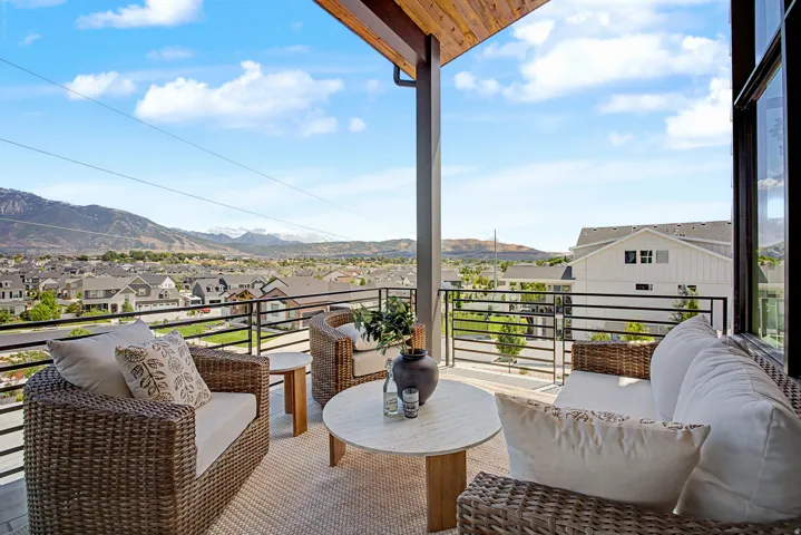 Expansive outdoor balcony featuring a wood-finish ceiling, black metal railings, and a hard surface floor