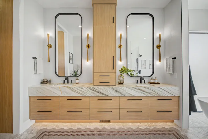 Dual wood-finish vanities with a floating design, featuring a substantial stone countertop and integrated rectangular sinks