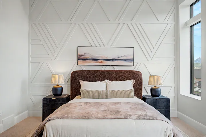 Feature wall with geometric paneling, carpeted flooring, and a large window with mountain scenery