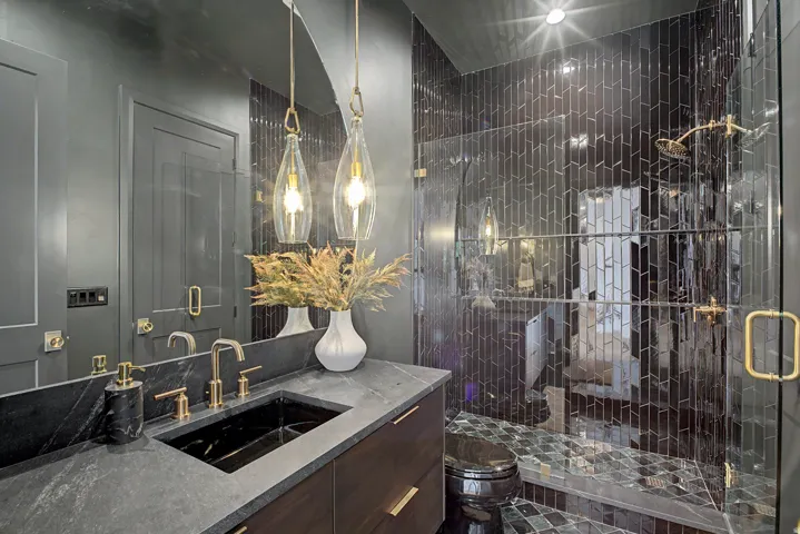 Bathroom featuring a dark wood-finish vanity with a dark stone countertop