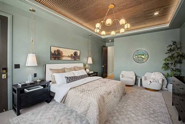 Bedroom featuring a wood-panel accent ceiling with recessed lighting, an ornate chandelier, and two pendant lights