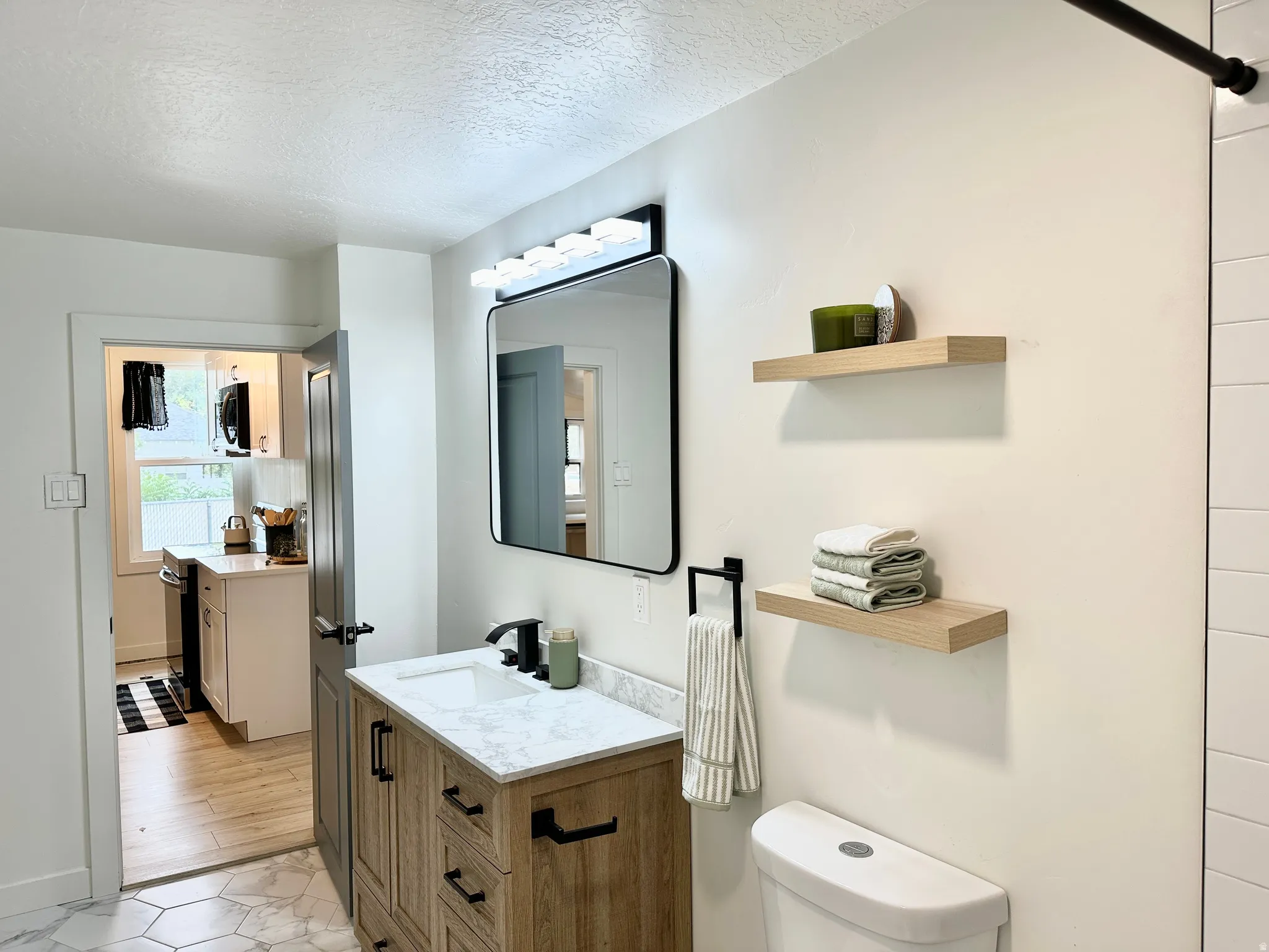 Bathroom featuring a wood-finish vanity with a white quartz countertop and rectangular sink