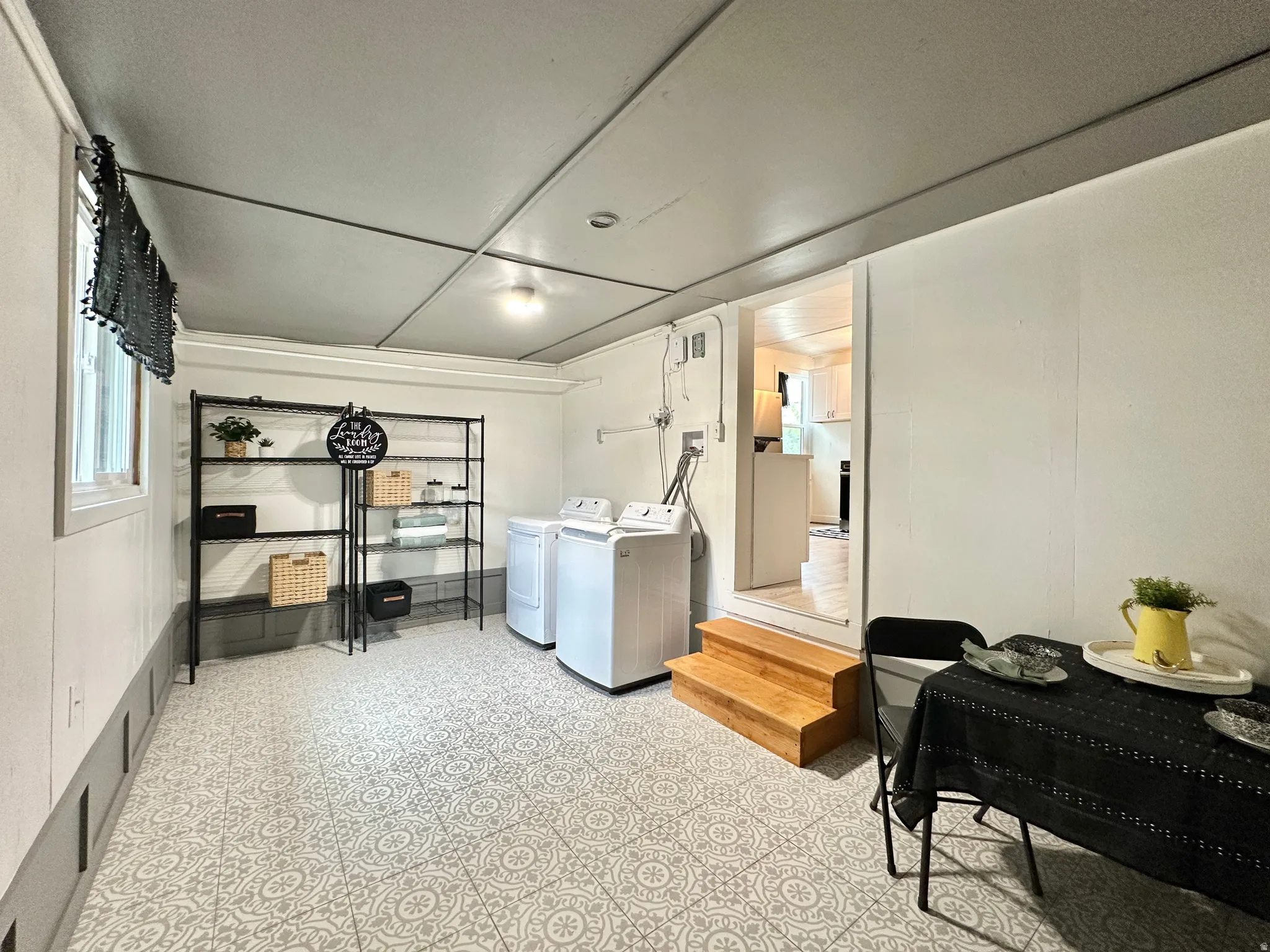 Laundry room & flex space for dining area, exercise equipment, storage or whatever you need. Featuring patterned floor tiles, and a recessed ceiling