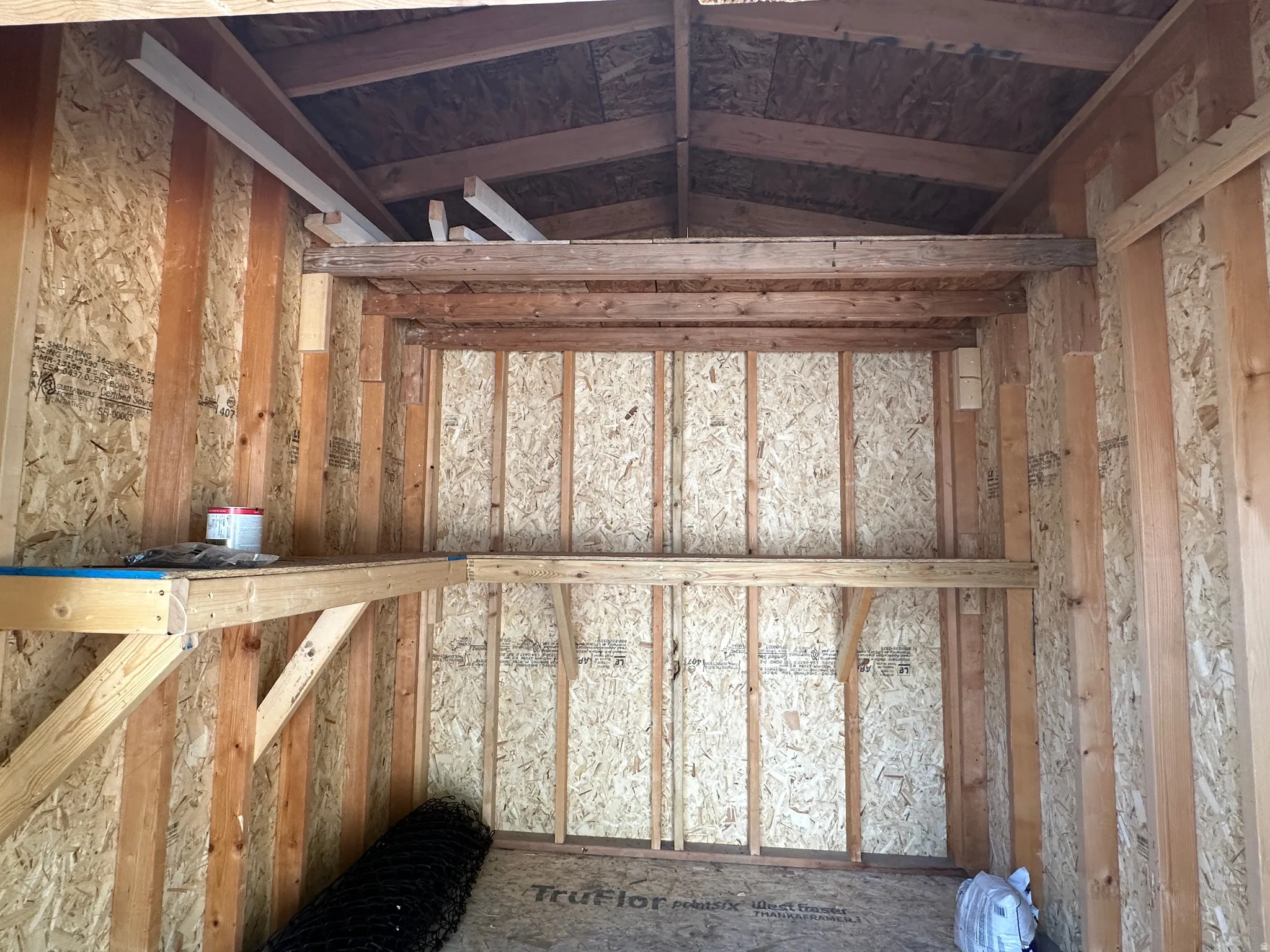 Interior space featuring exposed wood framing and oriented strand board walls