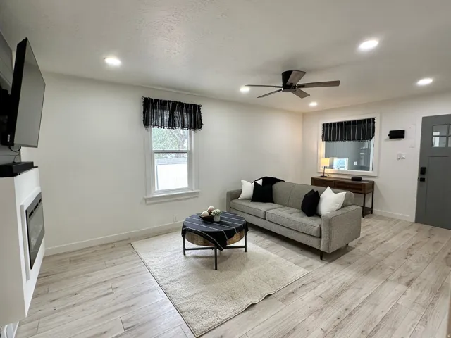 Living area featuring wood-finish flooring, recessed lighting, and a modern ceiling fan