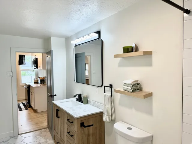 Bathroom featuring a wood-finish vanity with a white quartz countertop and rectangular sink