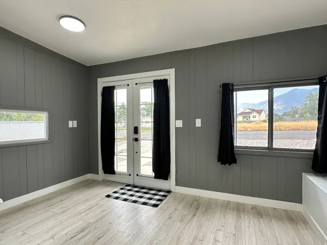 Front foyer featuring board and batten walls, light wood-finish flooring, and a ceiling-mounted light fixture