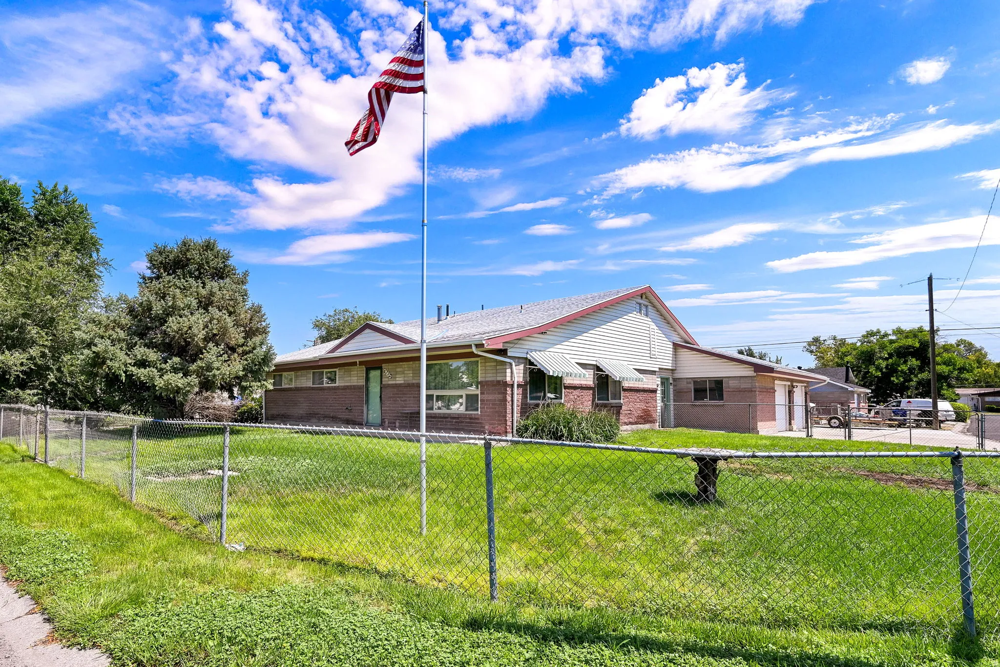 Ranch-style exterior featuring a multi-gable roofline, brick and siding facade, and multiple windows with awnings
