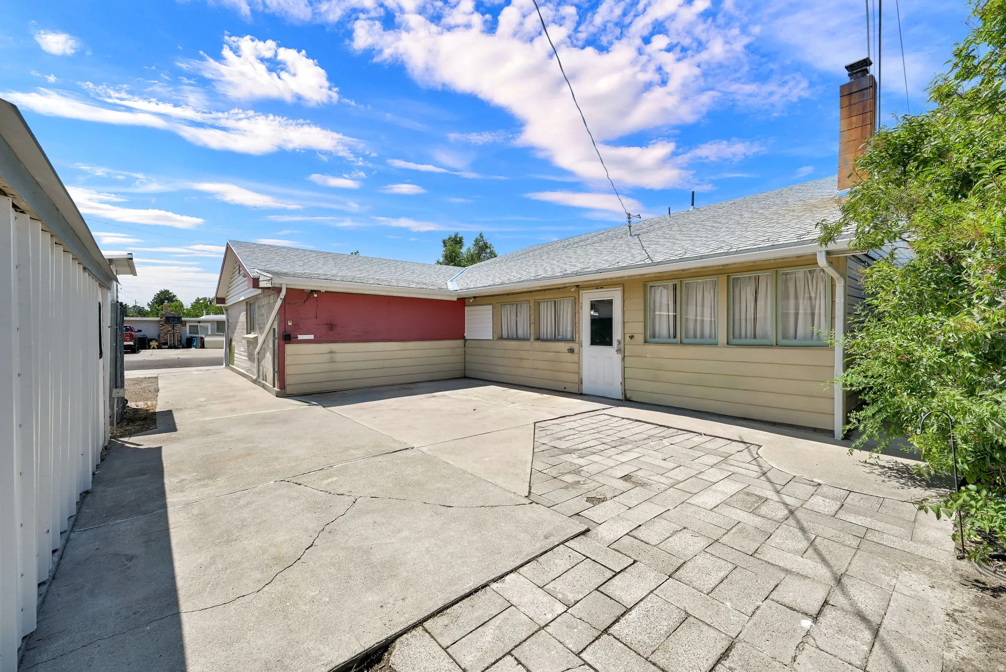 Property exterior with a light yellow siding and a red upper section