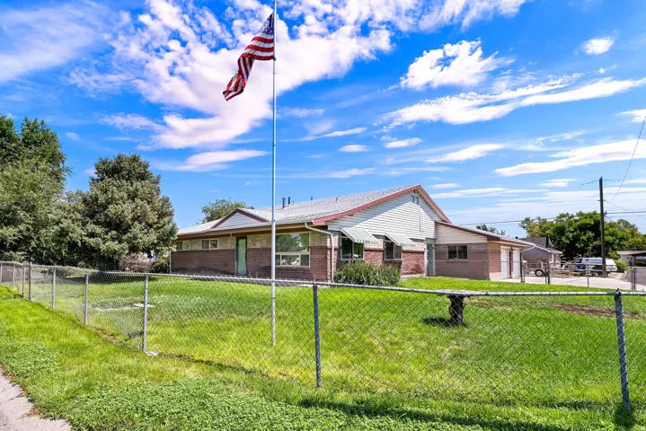 Ranch-style exterior featuring a multi-gable roofline, brick and siding facade, and multiple windows with awnings