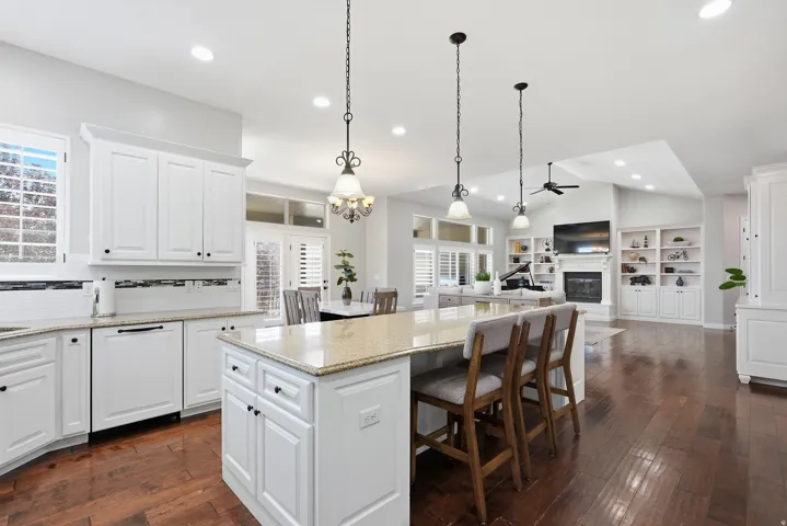 Bright kitchen featuring white cabinetry, light-toned countertops, and wood-finish flooring