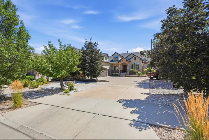 Stucco and stone exterior residence featuring a multi-gabled roofline, arched window, and prominent front entry
