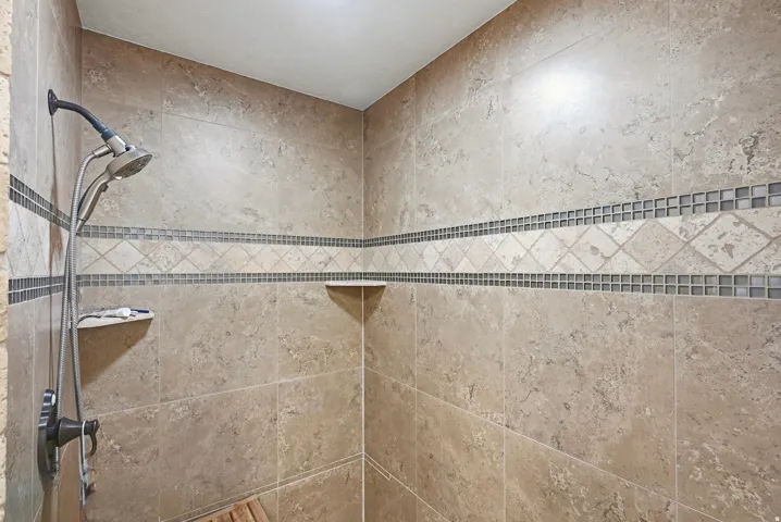 Tiled shower with a handheld showerhead and a fixed showerhead