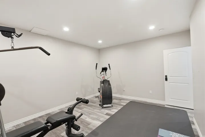 Versatile interior space featuring wood-finish flooring, recessed lighting, and a solid core interior door