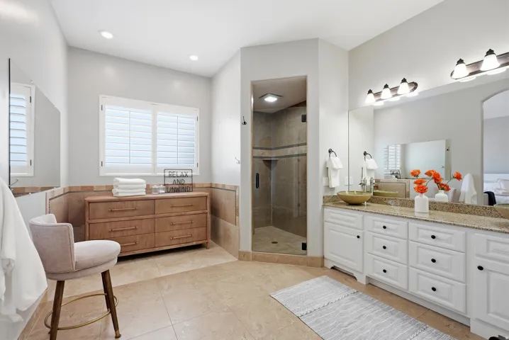 Spacious bathroom featuring a glass-enclosed shower, dual vanity with undermount sinks, and a large mirror