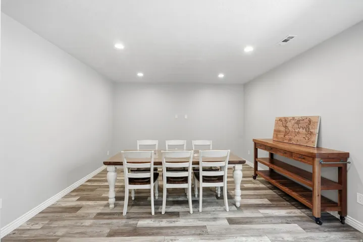 Spacious room with wood-finish flooring, recessed lighting, and light-toned walls
