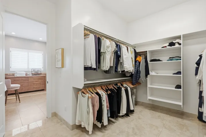 Custom closet system featuring multiple hanging rods and integrated shelving