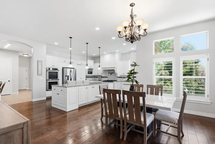 Open-concept kitchen and dining area featuring rich wood-finish flooring