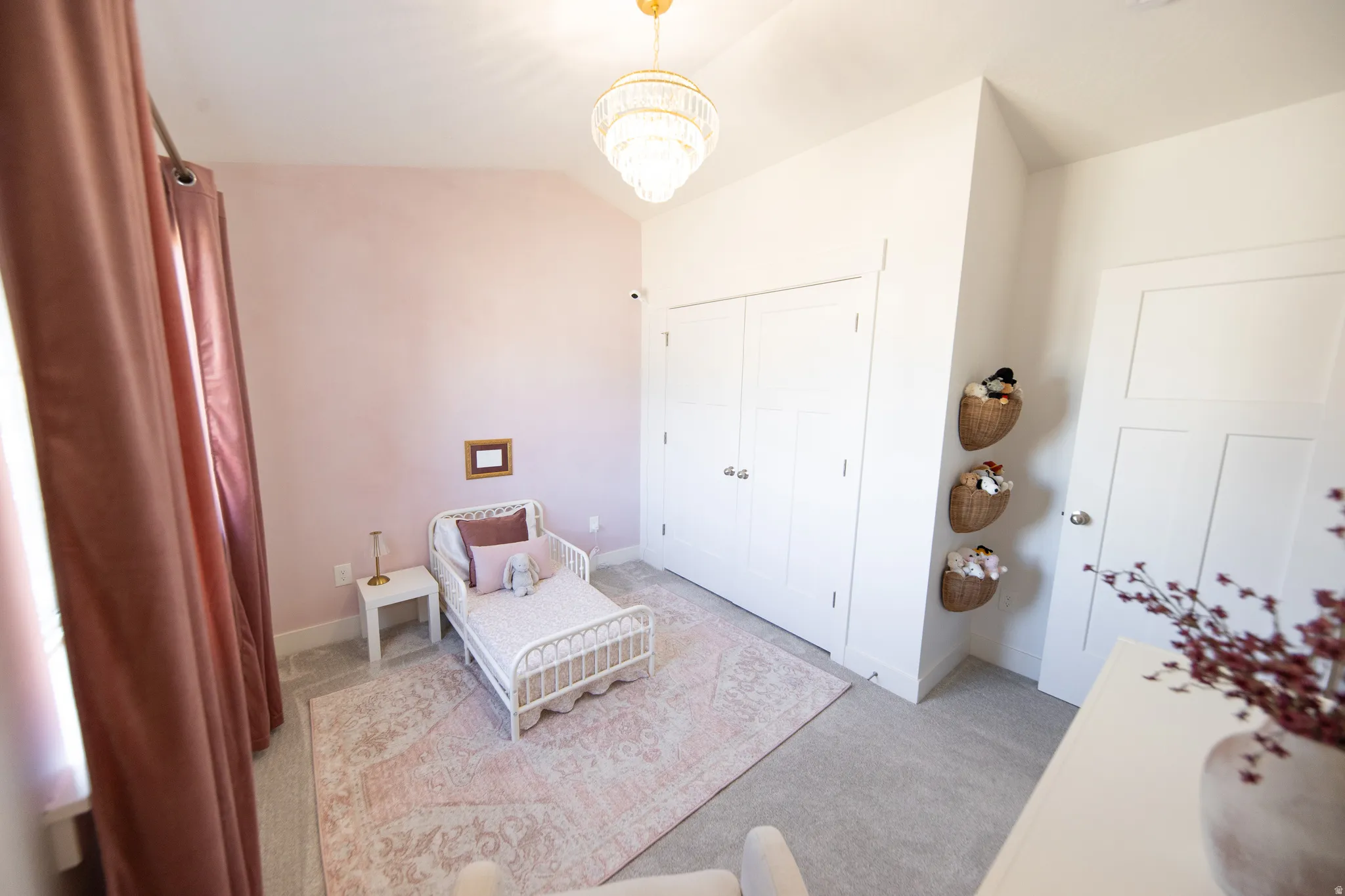 Bright room featuring a vaulted ceiling and a crystal chandelier