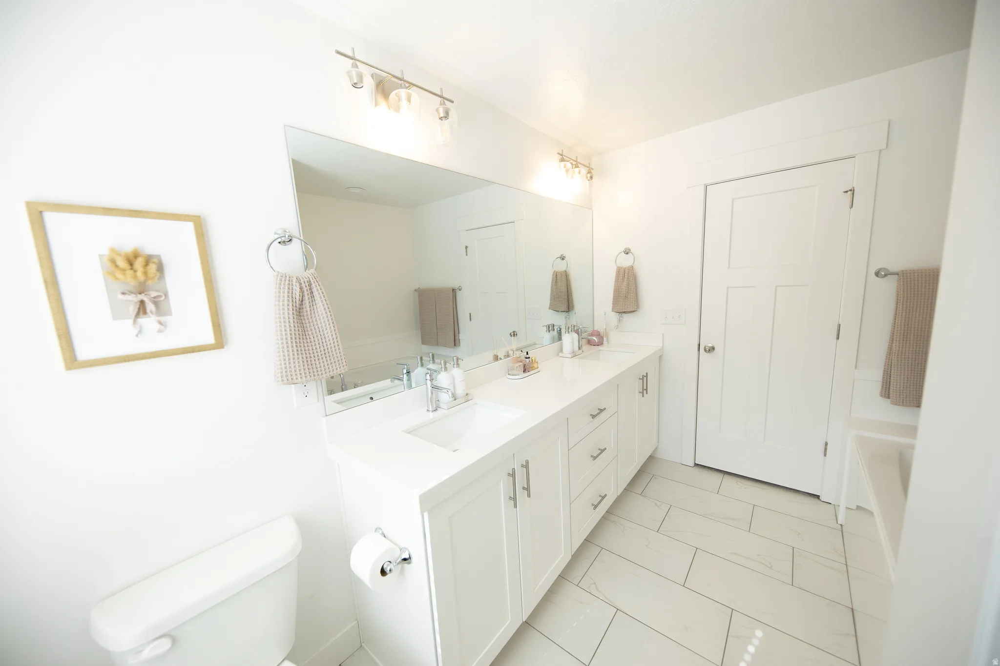Double vanity with undermount sinks, white cabinetry, and a spacious countertop
