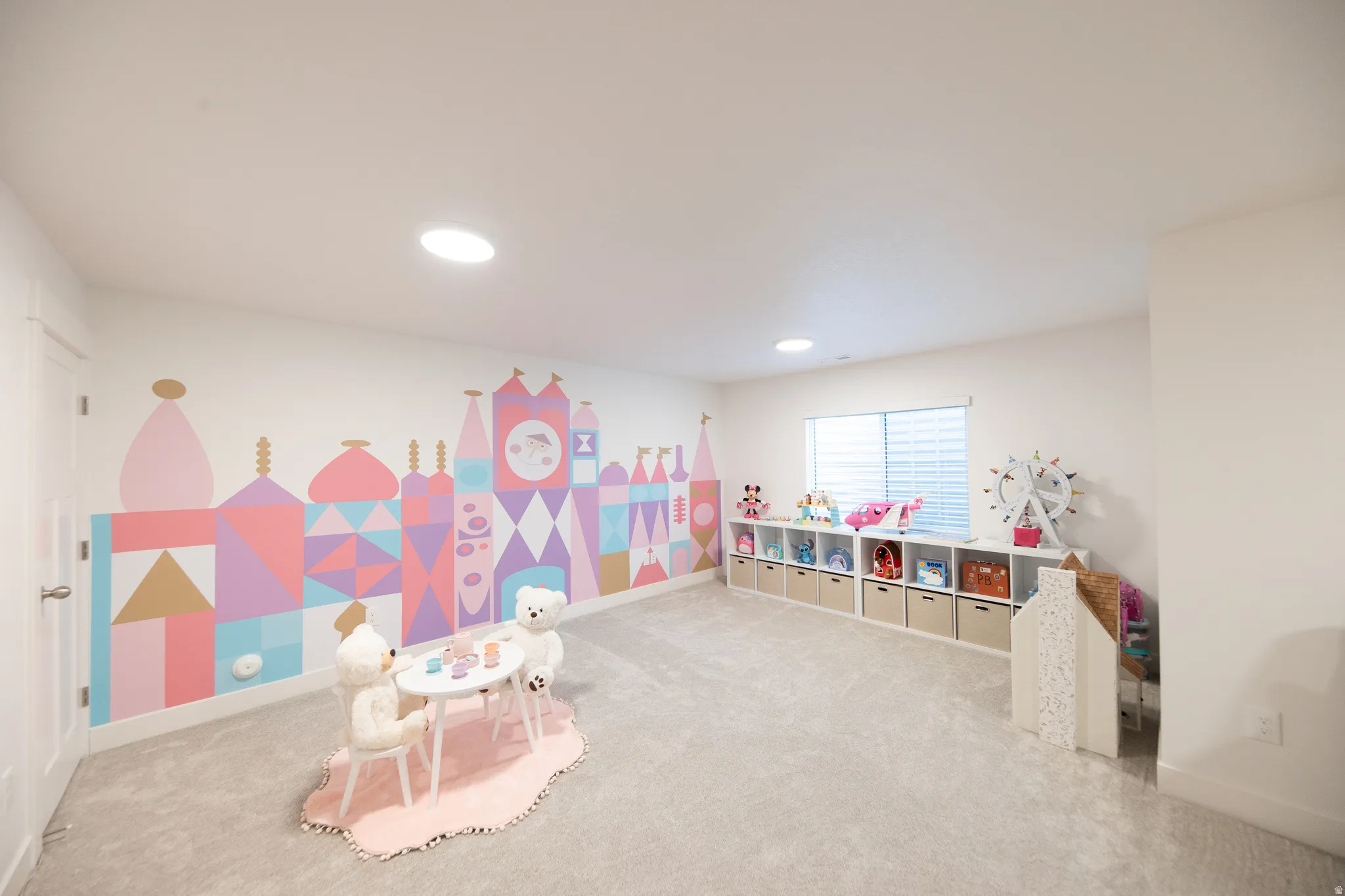 Spacious room featuring light gray carpeting and a vibrant mural wall
