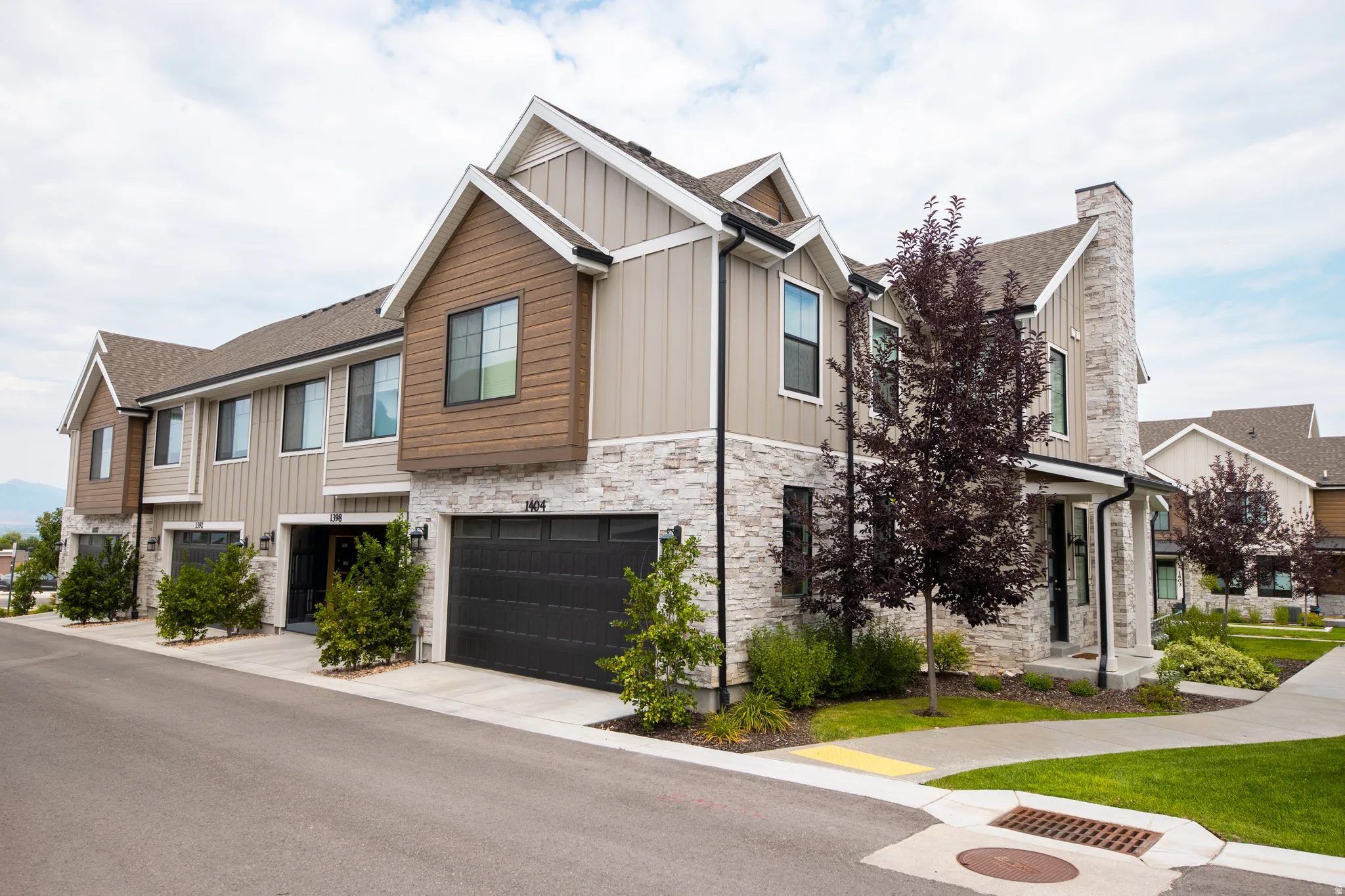 Contemporary townhome exterior featuring stone accents and vertical siding