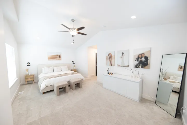 Spacious room featuring vaulted ceilings, recessed lighting, and light-toned carpeting