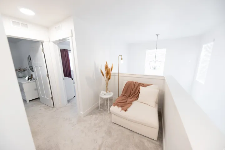 Carpeted hallway featuring a skylight and a white railing overlooking a lower level
