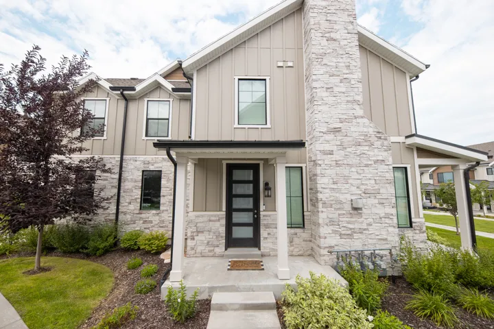 Contemporary home exterior featuring board and batten siding and light-colored stacked stone accents