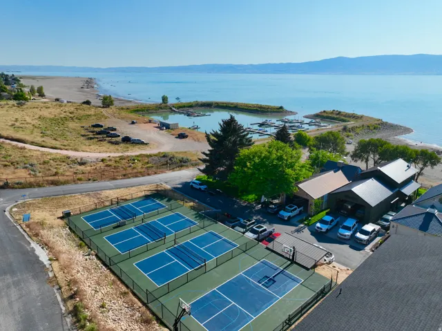 Lakeside property featuring recreational courts, a private marina, and direct beach access