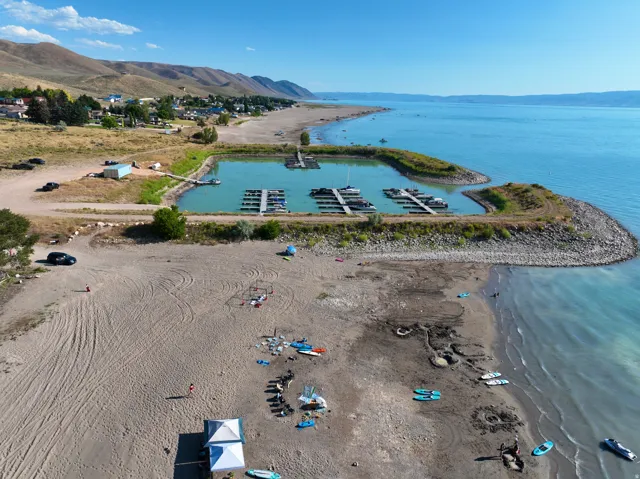 Expansive waterfront property featuring a private marina with multiple boat slips, direct beach access, and a wide sandy shoreline