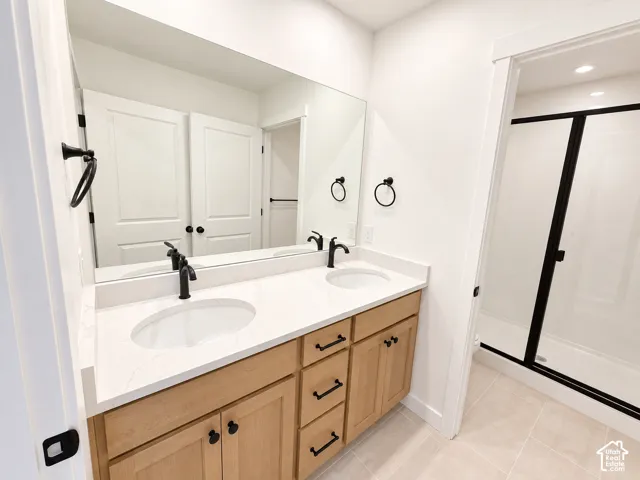 Dual vanity with light wood-finish cabinetry, white countertop, and matte black fixtures