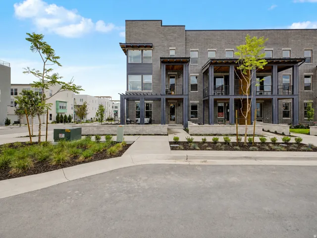 Contemporary townhome featuring a dark brick facade and multi-level balconies with dark metal railings