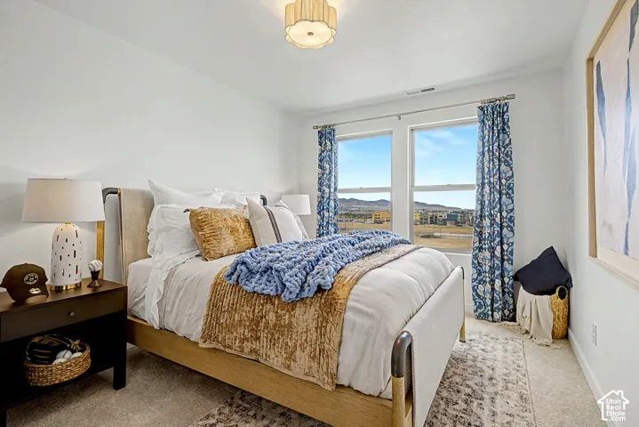 Carpeted bedroom with a double window, recessed ceiling light, and a dark wood finish nightstand