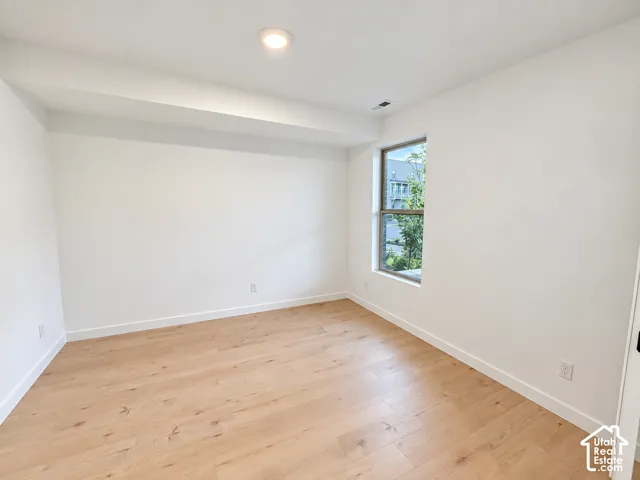 Recessed ceiling lighting, wood-finish flooring, and a window with exterior views
