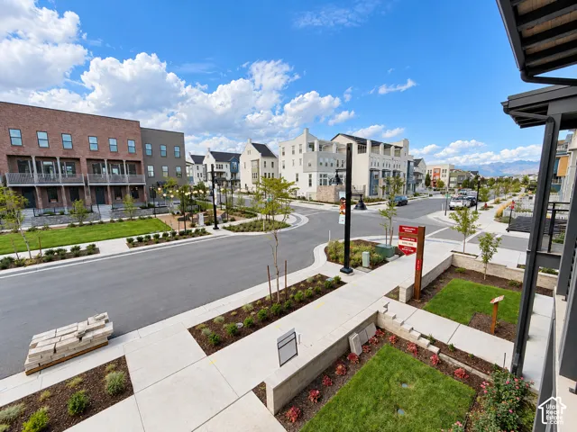 Community featuring brick and stucco townhomes, paved streets, and sidewalks with landscaped planters