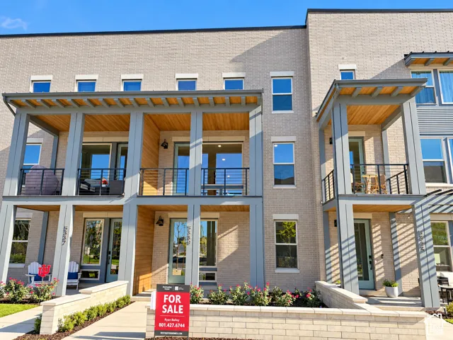 Modern multi-story facade featuring light brick and horizontal siding