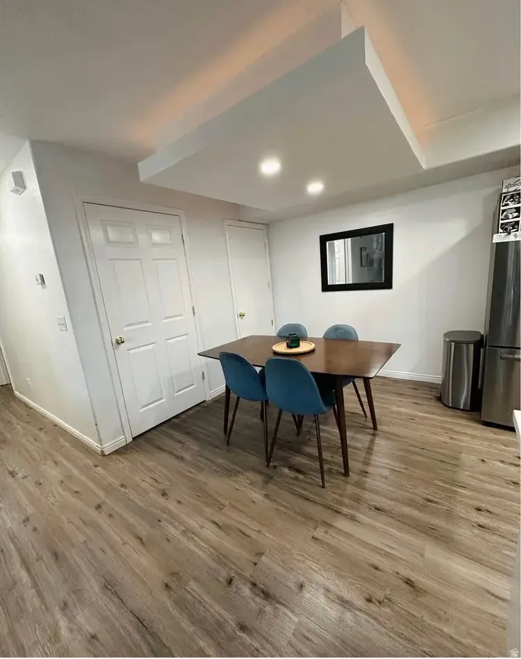 Dining area featuring wood-finish flooring, recessed lighting, and a contemporary dropped ceiling detail