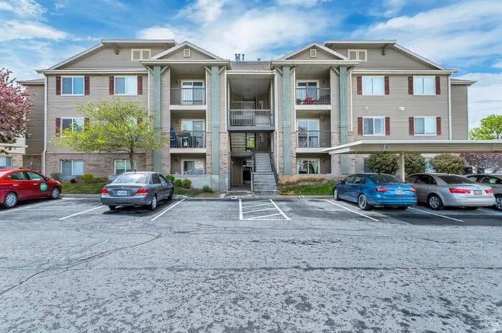 Multi-level residential building featuring private balconies, exterior stair access, and covered parking