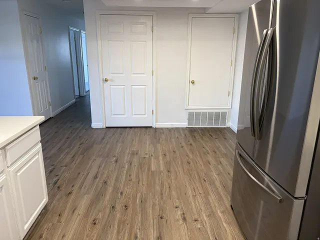 Wood-finish flooring throughout, with white cabinetry and a light-toned countertop