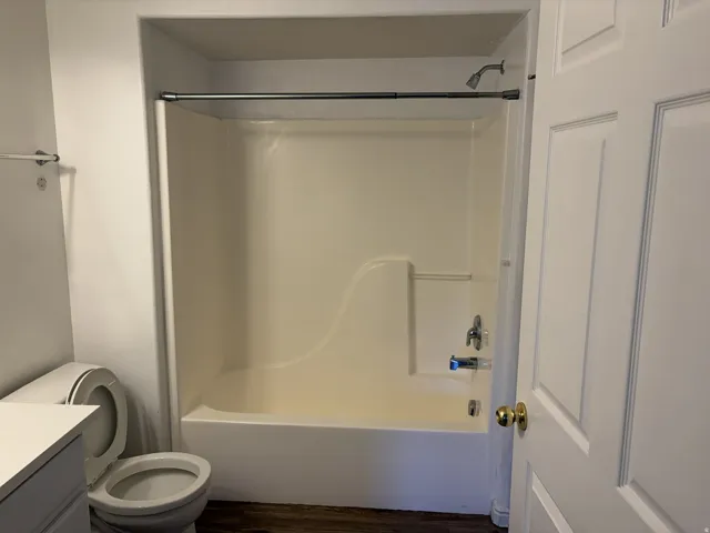 Tub and shower combination with a single-handle faucet, integrated soap dish, and a ceiling-mounted showerhead