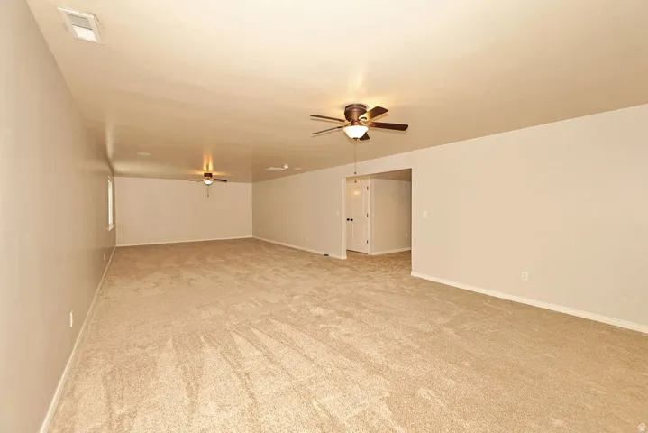 Spacious open floor plan with neutral wall finishes, wood-finish flooring throughout, and recessed ceiling lighting