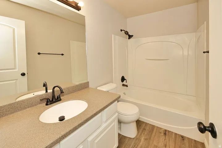 Bathroom featuring a white vanity with a speckled countertop, undermount sink, and oil-rubbed bronze fixtures