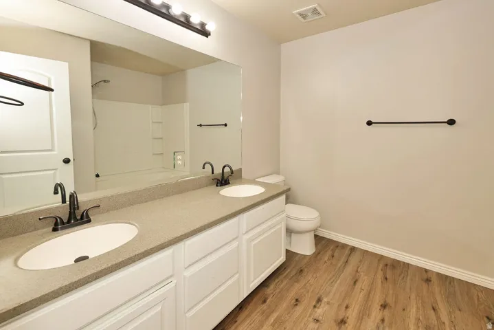 Dual-sink vanity bathroom featuring white cabinetry, quartz countertops, ceramic round vessel sinks, and matte black hardware